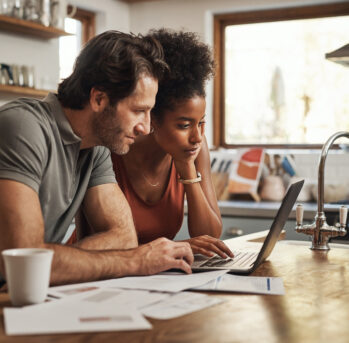 Young couple looking at laptop in the kitchen